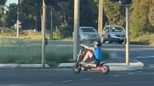 Young boy riding e-scooter on busy Craigmore road