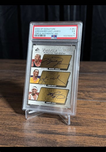 This modern card-collecting grail was just consigned to our Spring Catalog Auction in April! One of the most coveted and prized signed basketball inserts, this 2004-2005 Upper Deck SP Signature Triple Authentic Signatures is serial-numbered “12/25,” and features on-card autographs of Michael Jordan, Kobe Bryant, and LeBron James. Each player has boldly signed in blue-fine point marker on the gold foil panel adjacent to his respective image. This remarkable card unites three of the NBA’s all-time