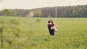 Loving couple swirl around in a field. Happy man and woman look at each other, womans hair sway in the air, slow mo