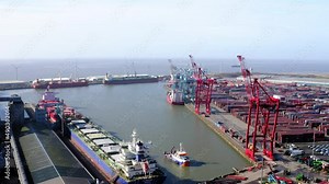 Ship dock yard with tower cranes. Bootle docks Liverpool showing ship in port and shipping containers.