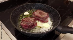 Filet mignon is fried in a frying pan in butter with spices