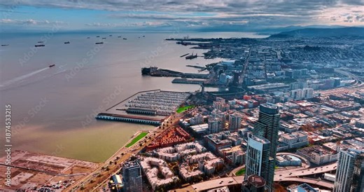 Urban waterfront of modern San Francisco, California, United States. Multiple vessels are on the peaceful waterscape of the bay. Aerial view.