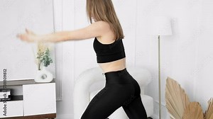 Fit woman making fitness aerobic exercise at home. Young woman stretching body. Beautiful woman in sports clothes training at home. 4K, UHD