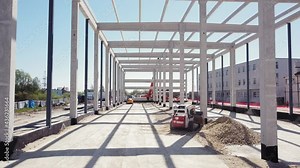 Modern Mini excavator Leveling The Ground With The Front Bucket On The Construction Site. Flight Over The Construction Site. Leveling And Compaction Of Soil On The Construction Site.