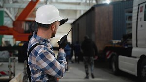 Worker managing modular home loading onto a transport truck