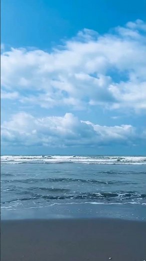Beautiful Ocean Waves by the Shore Under a Blue Sky with Clouds