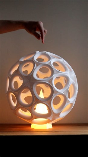 Gregory Mann on Instagram: "The form of this lamp comes from a geometric shape called a pentagonal hexecontahedron. It belongs to a family of shapes known as Catalan solids, highly symmetrical forms made from many identical faces. They’re the geometric counterparts to the Archimedean solids, like two sides of the same mathematical coin. In this case, the shape is built from 60 identical pentagonal faces arranged so the overall form becomes almost spherical. That balance between repetition and cu