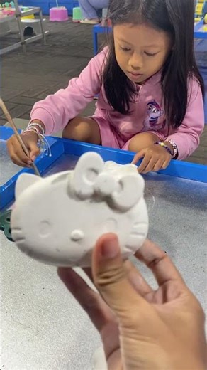 Sabiya's sister colors the Hello Kitty statue