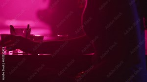 Woman glass on bar in pink light