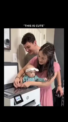 ai creators on Instagram: "The video shows a young couple making a heartfelt family keepsake. The mother, dressed in pink, gently holds their baby, who is wearing a green outfit with a matching headband, while the father carefully places the baby’s tiny hand on the glass of an HP printer scanner. Their own hands rest over the baby’s, symbolizing togetherness. They scan the image, revealing a black-and-white print of the overlapping hands, which they later frame as a cherished memory. Softly play