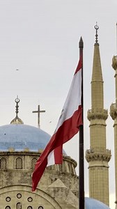 Beirut, Lebanon 01 26 2025: Al Amin mosque with blue domes alongside Christian church with a cross in downtown Beirut. Lebanese flag prominent. Diversity, religious coexistence, and national identity.