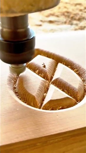 A CNC router bit is carving a circular decorative pattern into a wooden block