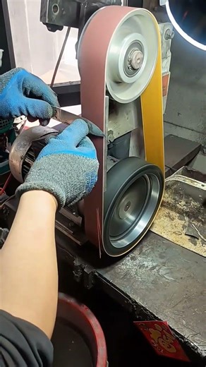 Professional belt sander machine sharpening a sharp metal blade