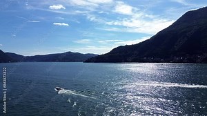 breathtaking tracking shot of aerial view of fast motorboats and slow old boats crossing themselth on water Como lake on a summer morning 8
