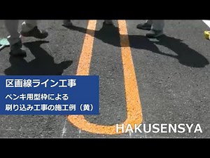 駐車場に型枠を使って黄色のペンキで区画線ラインを書く