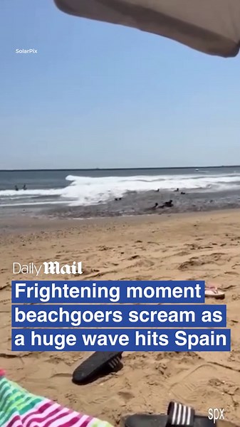 Moment beachgoers scream in fear as huge wave hits beach in Spain