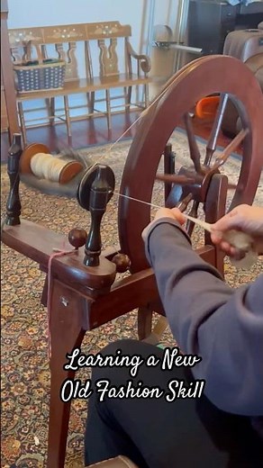 Learning to spin yarn on a vintage wheel
