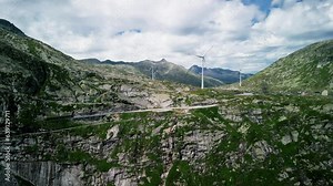 alpine wind turbines at an altitude of 2000 meters, turbines against the backdrop of mountains, ecology, wind energy, smooth shooting from a drone 4K