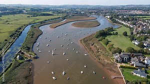Aerial view of Topsham, Devon, highlights the River Exe and town. Captures the vibrant community, scenic riverside, and urban charm. Perfect for travel and cultural documentaries.