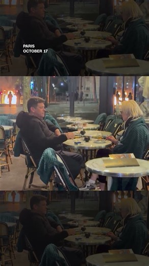French couple casually drinks wine as Paris burns