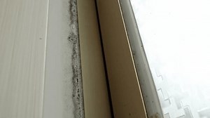 An old anodized aluminum window infested with mold