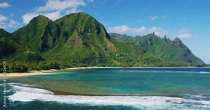 Cinematic aerial view of dramatic mountains and beautiful ocean on North Shore of Kauai