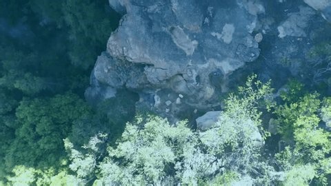 clip-3985385883-drone-panning-revealing-slackline-man-balancing-traversing