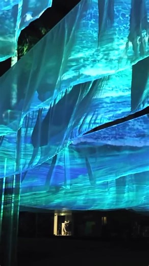 PMW Projection Mapping & New Media Arts on Instagram: "A Question of Blue 20x30m Digital Art Projection @bonifaciohighstreet (near Fully Booked) The artwork shows the motion of real life footage waves on the cloth while overlaying digital, intricate fractals, creating a fusion of natural spontaneity and mathematical precision. The artwork invites us to not only see beauty but to question it—to ask why the ocean and sky take on their mesmerizing hues. It stirs curiosity, encouraging us to look de