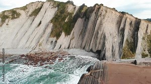 Aerial drone view of famous flysch of Zumaia, Basque Country, Spain. Flysch is a sequence of sedimentary rock layers that progress from deep-water