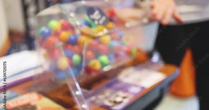 Process of prize drawings, extracting a winning numbers of lottery machine, raffle drum with a bingo balls, bingo machine and winning tickets on event with a host, hands on lottery machine
