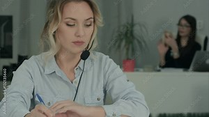 Busy call center agent using digital tablet on a call at her workplace
