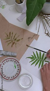 Painting a fern leaf with watercolor to be use as pattern on recycled paper, DIY creative project using eco-friendly sustainable materials