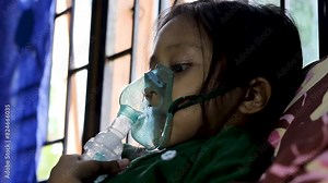 Close-up video, a little girl with asthma is undergoing nebolizer treatment. Home care