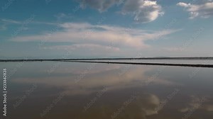 Alykes the Hellenic saltworks located outside of Mesolongi in Greece. Drone footage with the clouds reflection in the salt water.
