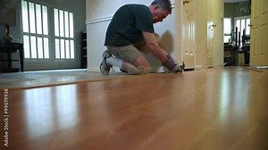 A homeowner handyman type removing quarter round shoe molding as part of his DIY project to replace old flooring.