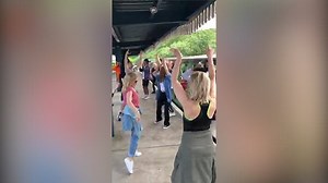Kylie doing the Locomotion on a train