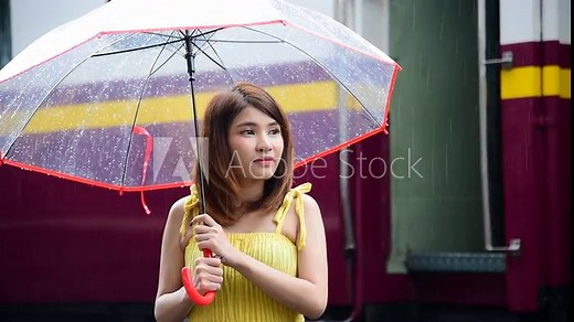 Young woman holding umbrella outdoor while heavy raining. Asian women hold umbrellas in hands outdoor green nature park. Fresh Air cool weather portrait women outdoor travel in rainy season