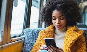 Young woman engaging with social media and browsing the internet while using a smartphone on public transportation. Enjoying her commute with digital connectivity and interaction