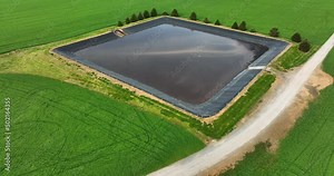 Water in retention basin at farm. Agriculture protect runoff and stormwater. Aerial in rural America surrounded by green field.