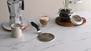 Induction Adapter for Coffee Makers Allows you to use traditional coffee machines on induction hobs thanks to this practical adapter made of 18% stainless steel. Its flat, sturdy design distributes heat evenly, facilitating efficient and safe heating. The heat-resistant bakelite handle ensures a comfortable and safe grip during use. Ideal for Italian coffee machines and other non-induction compatible cookware. A simple and long-lasting solution to continue enjoying the coffee you've always enjoy