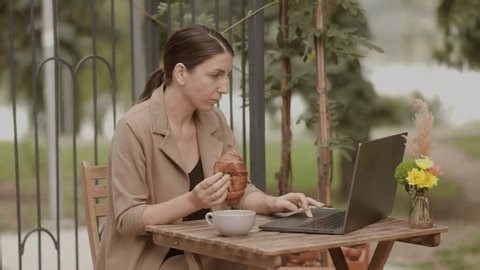 clip-4015510191-focused-brunette-woman-works-on-her-laptop