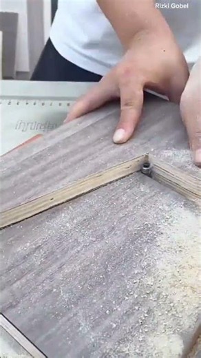 using a table router machine to cut and trim an inner pattern on a wood-grained plywood board
