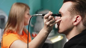 In a modern clinic, an ophthalmologist performs an eye ultrasound (B-scan) for an in-depth examination of the eyes of a young man. The concept of modern technologies for vision diagnostics.