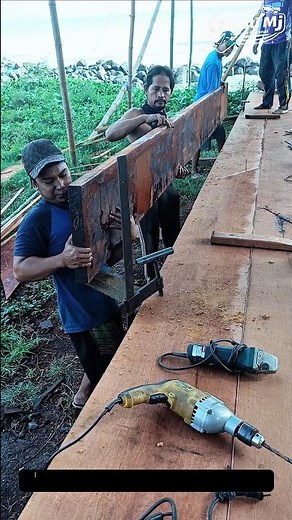 Aligning Long Wooden Planks in Boat Construction | Teamwork and Precision at the Shipyard.