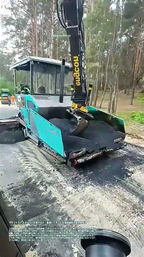 バケットでアスファルトを撒き出す：重機と人手による道路舗装の省力施工法