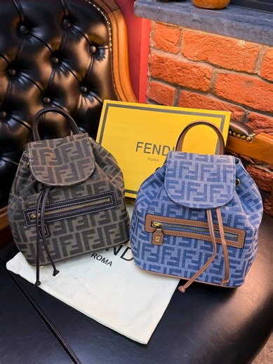 Fendi FF jacquard fabric Backpack Brown Blue Backpack with a soft, deconstructed design decorated with an FF clasp. Made of iconic, tobacco-brown FF jacquard, with base and details in dark brown & blue calfskin. Features a front flap, magnetic button clasp and drawstring closure, with tone-on-tone leather cords and customised details. Lined internal compartment and gold-finish metalware. Adjustable leather handle and thin shoulder straps. Made in Italy Measurements Height : 26 cm Depth : 12 cm W