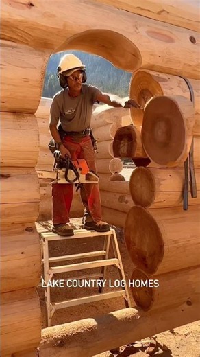 One of or awesome log home builders cutting an Archway in a Western Red Cedar Log Wall for a cabin.