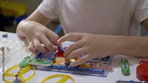 Curious Boy Assembles Electrical Circuit of Metal Construction Kit Parts. 4K