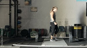 Female weight lifter loading weights onto a bar in the gym