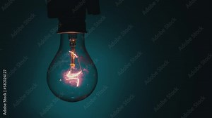 Light bulb flashes on a blue background in the dark. Slow turning on and off of a tungsten light bulb. Filament of a blinking vintage light bulb. Energy, electricity, light, life.
